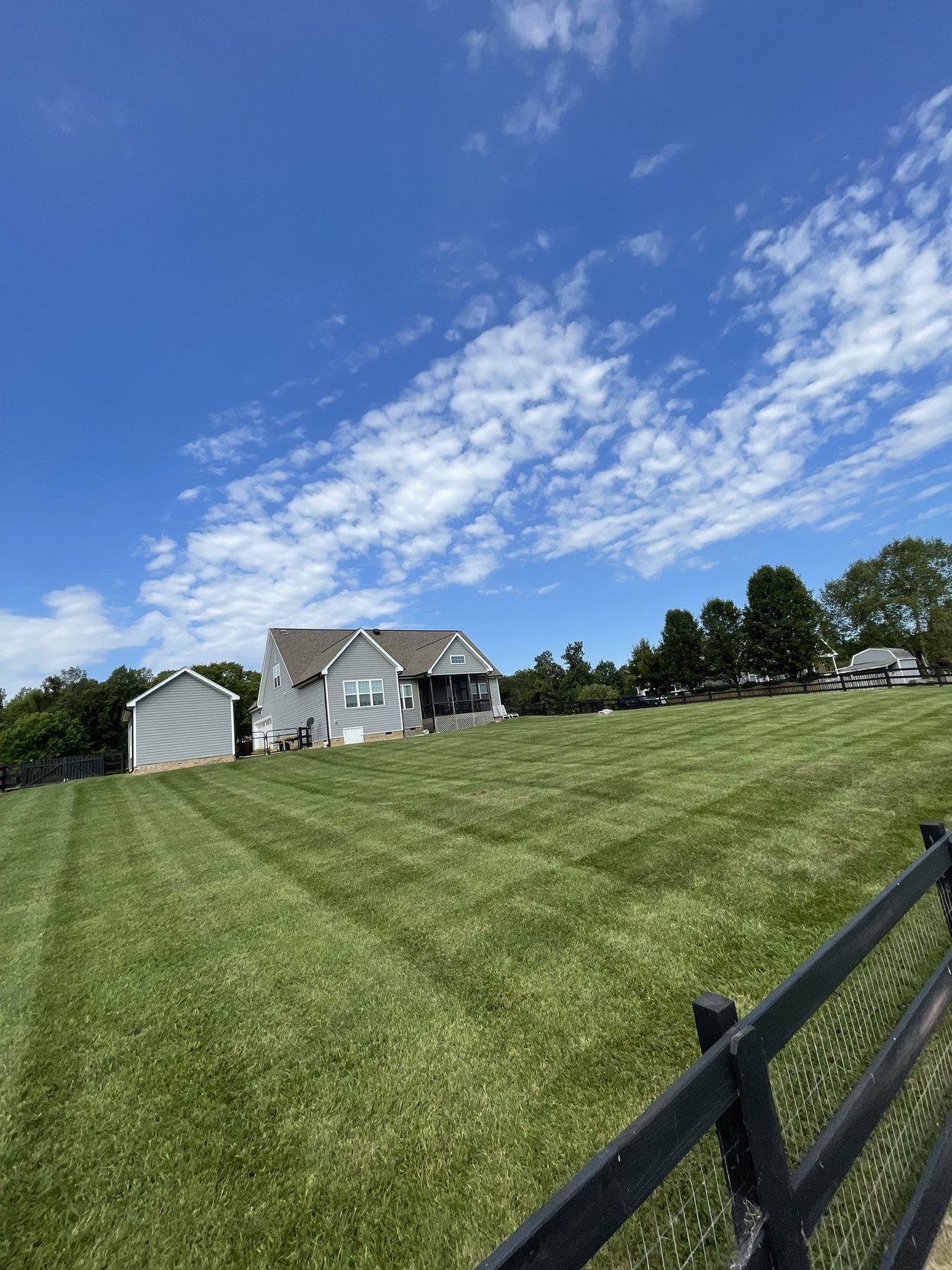 Large lawn beside a home under blue sky
